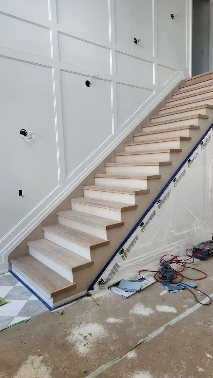 Interior painting by Sigma Painting — panelled stairwell finished in white above unstained oak treads