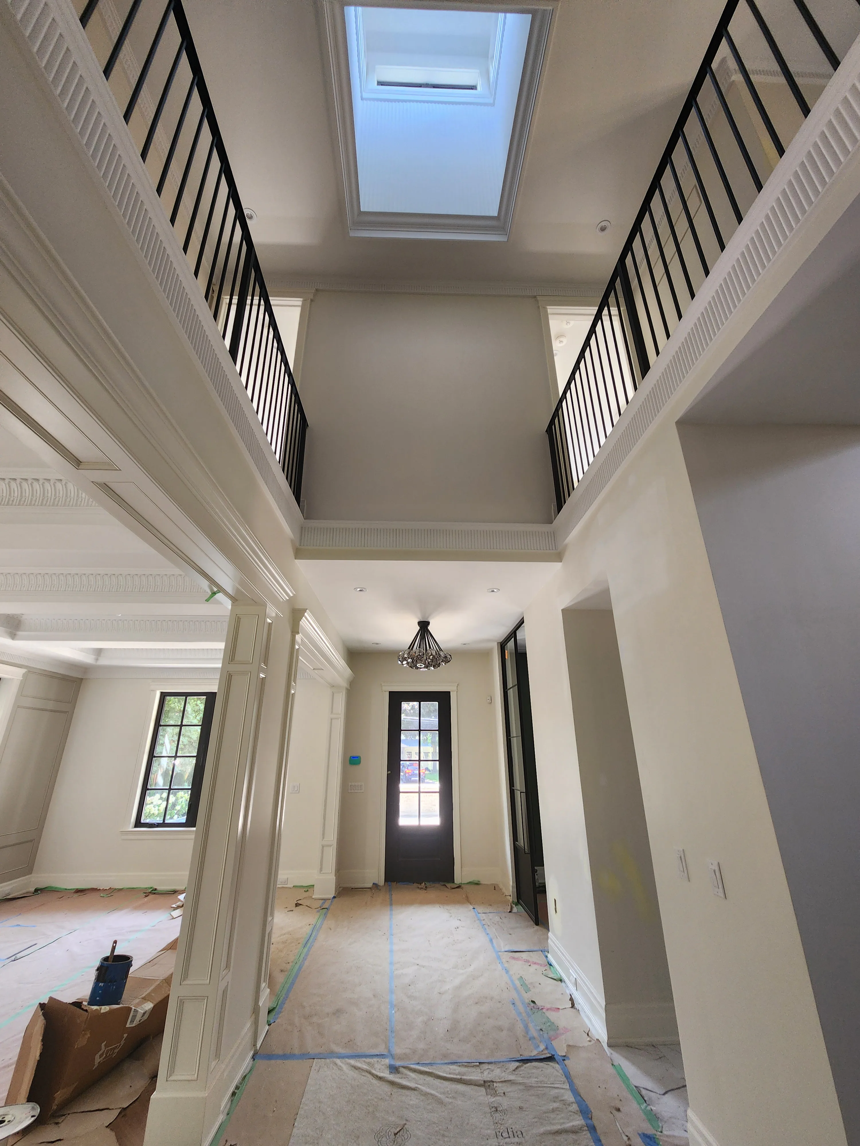 Interior painting by Sigma Painting — two-storey foyer with skylight, crown detail and black railings