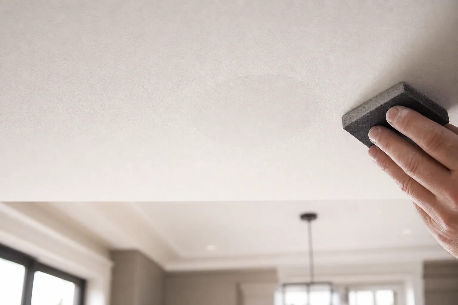 Ceiling patch after pot light removal being sanded smooth